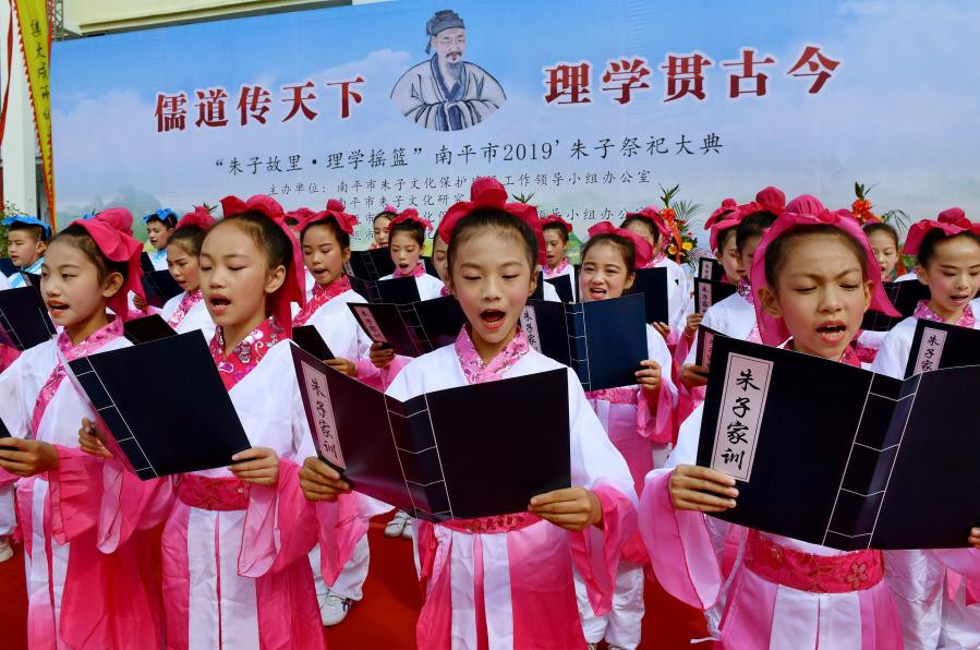 Általános iskolások Fucsien tartomány Csien-ou városában a Csu-ce emlékére rendezett áldási ceremónia alkalmából felolvassák Csu-ce családszabályait (forrás: news.cn)